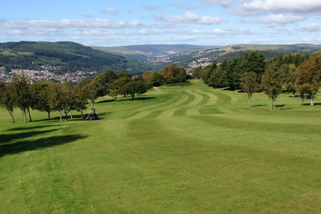 Looking back towards the 13th tee across a mown fairway, with Pontypridd spread out four hundred feet below